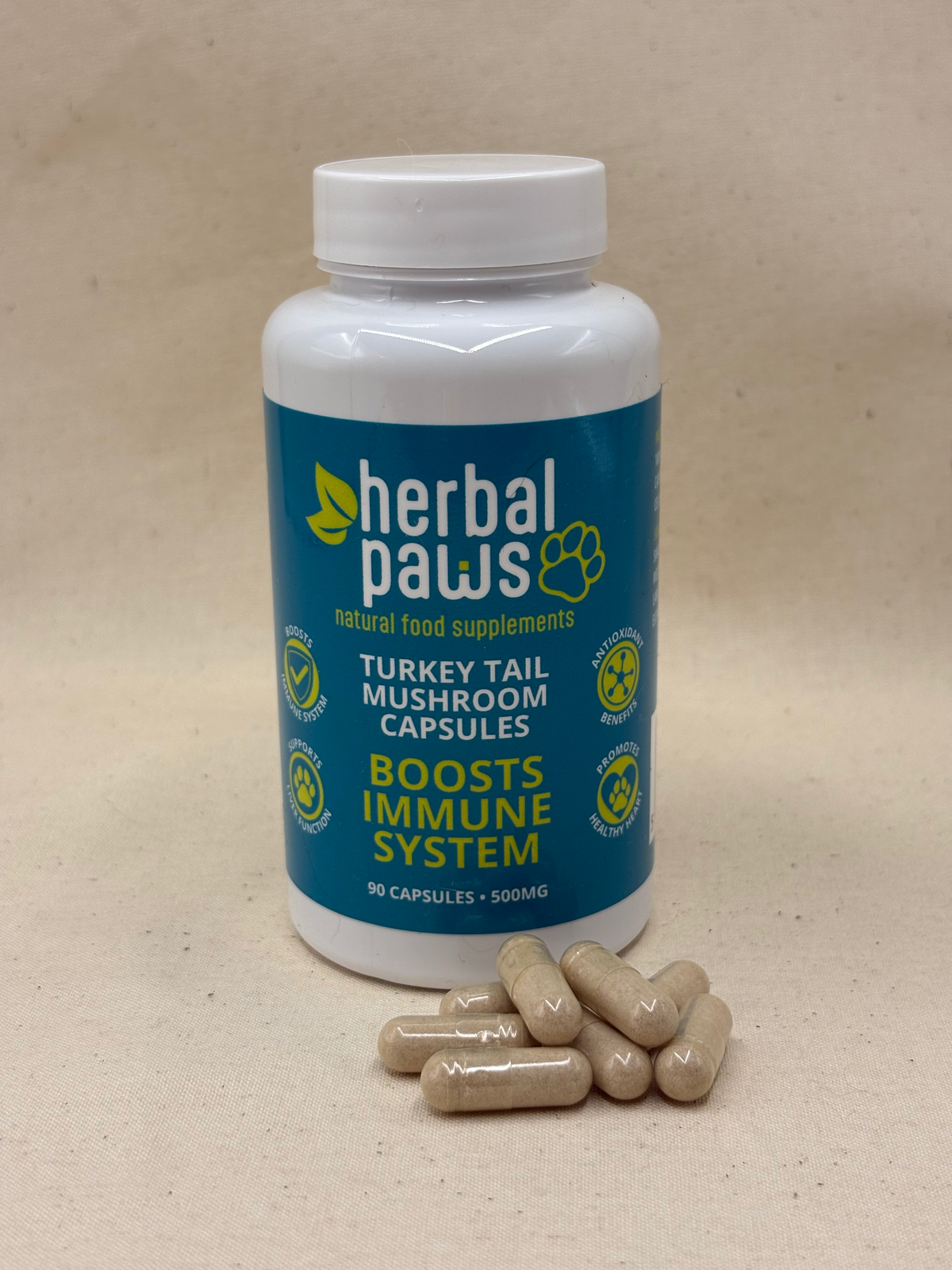 A white bottle of Herbal Paws Turkey Tail Mushroom Capsules supplement with a blue label, shown on a beige surface with several beige capsules placed in front.
